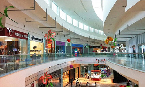 Picture of a major shopping center in Cancun, Mexico. The mall is 3 floors and shows shoppers in the main floor area.