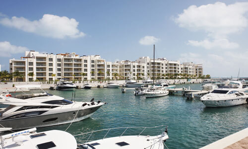 Picture of a beautiful marina in Cancun, Mexico. The picture shows several yachts and boats moored at the docks.