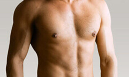 Close-up picture of a man, happy with his male breast reduction procedure he had in Cancun, Mexico.  The man is shown  standing,  to feature his male breast reduction.